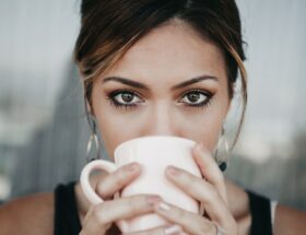 which is stronger latte or cappuccino woman drinking from white coffee cup
