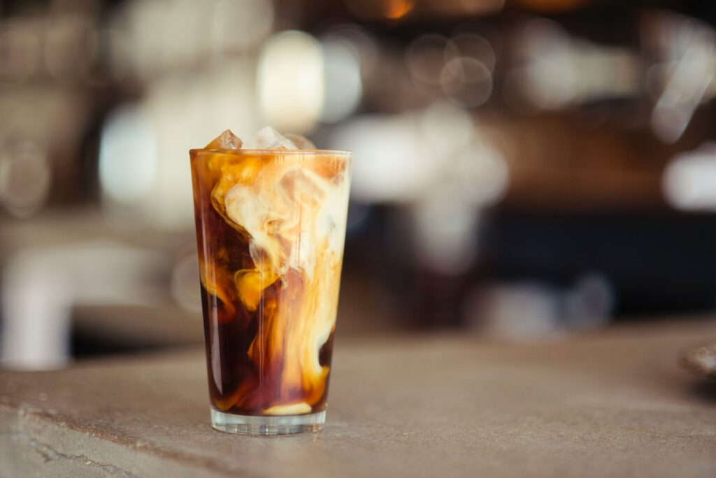 glass cup filled with ice latte on tabletop Amaretto Coffee