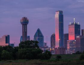 Best Coffee Roasters in Dallas Texas a view of a city skyline with a water tower in the foreground